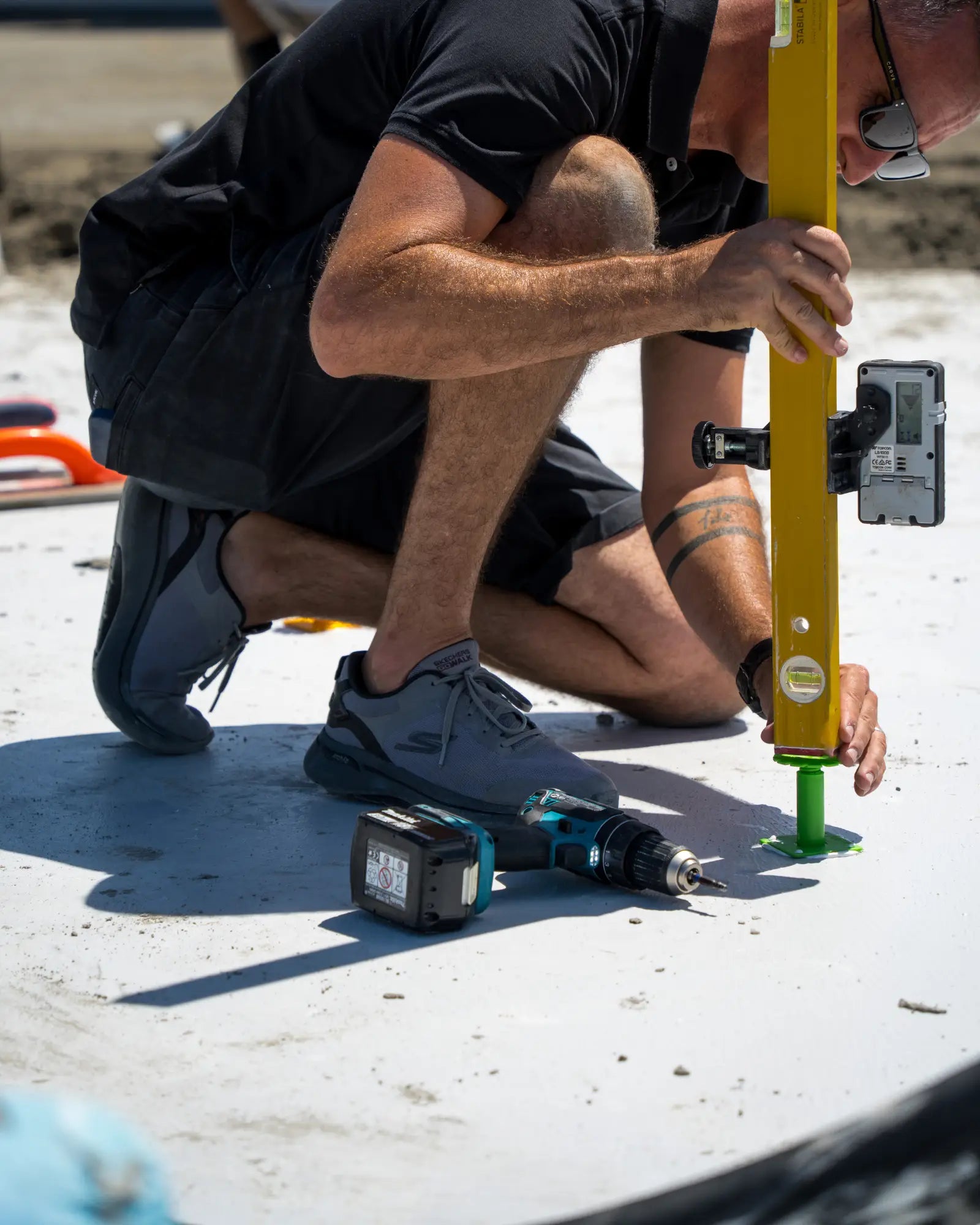 Tile installer checking floor level on Screedex® Large screed platform for thick-bed mortar installation