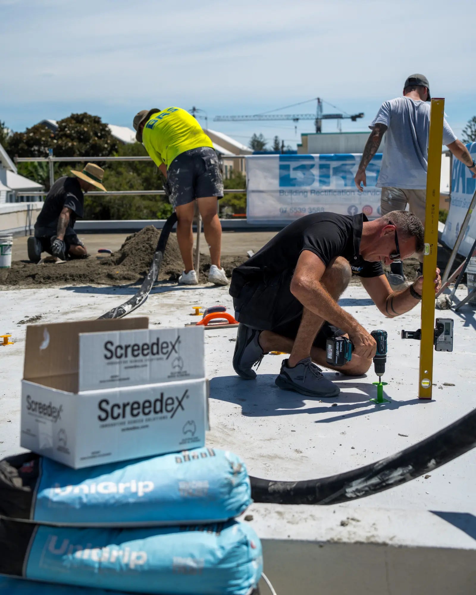 Screedex® founder on construction site setting out screed platforms and checking floor level and mortar bed slope